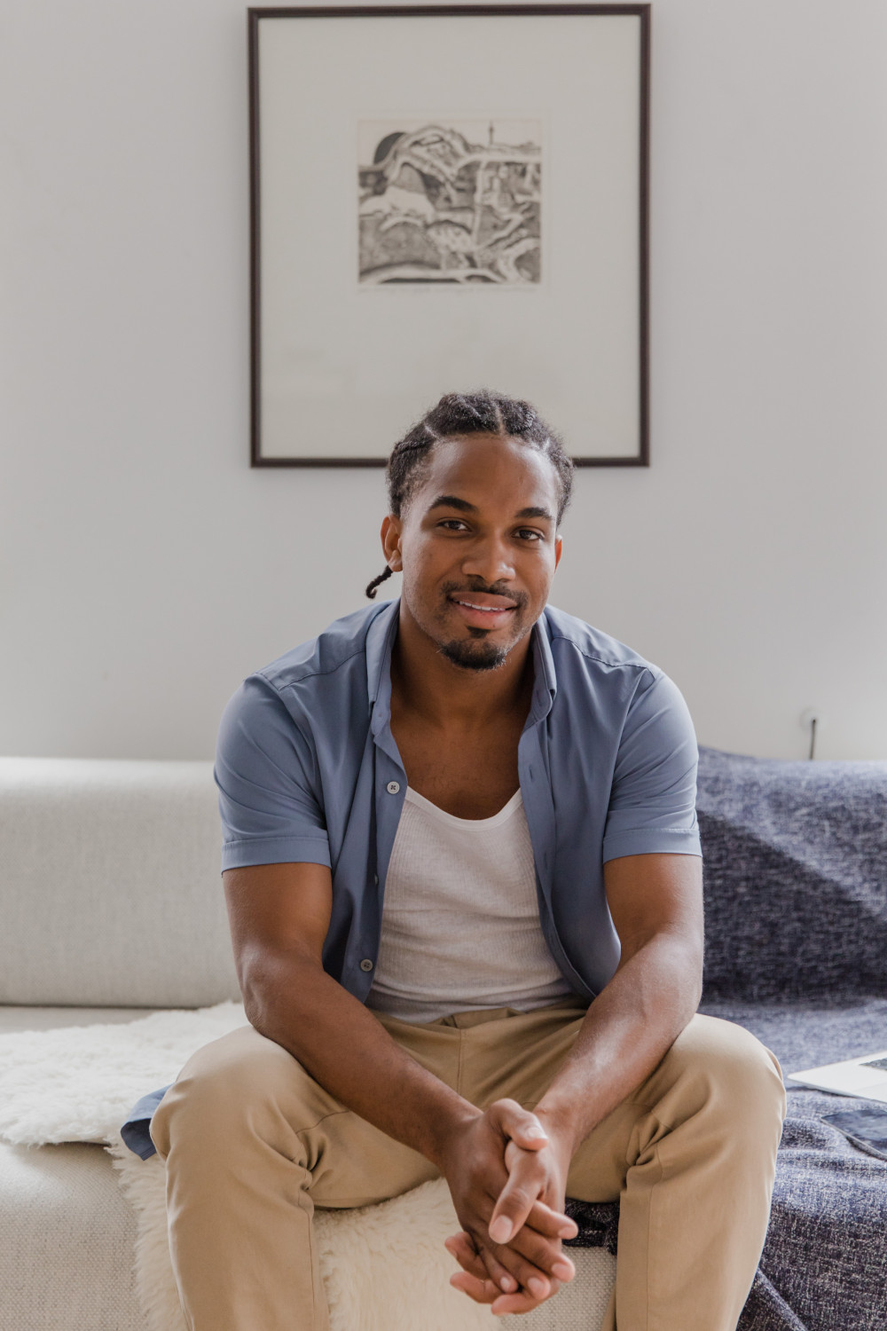 A man sitting on sofa with a painting hung on the wall